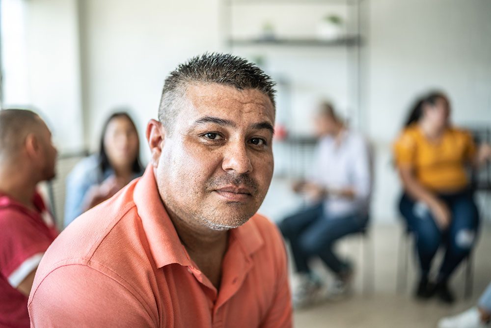 Portrait of middle-aged adult man during a group therapy at mental health center