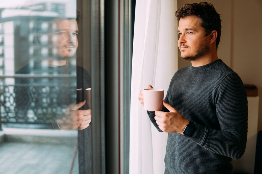 Outpatient Care for adults - pensive man standing by window